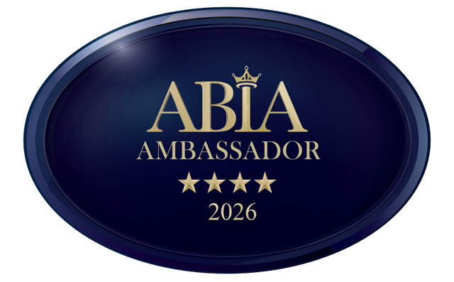 A dark blue oval badge with gold text reading "ABIA Ambassador 2026" and four gold stars below the text.