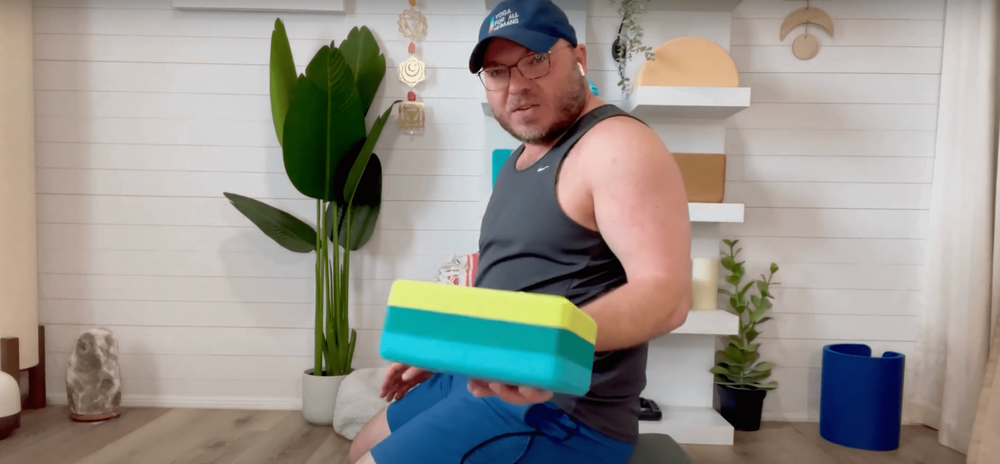 Yoga instructor Derek Haigler using yoga blocks to help him perform the Thunderbolt yoga pose