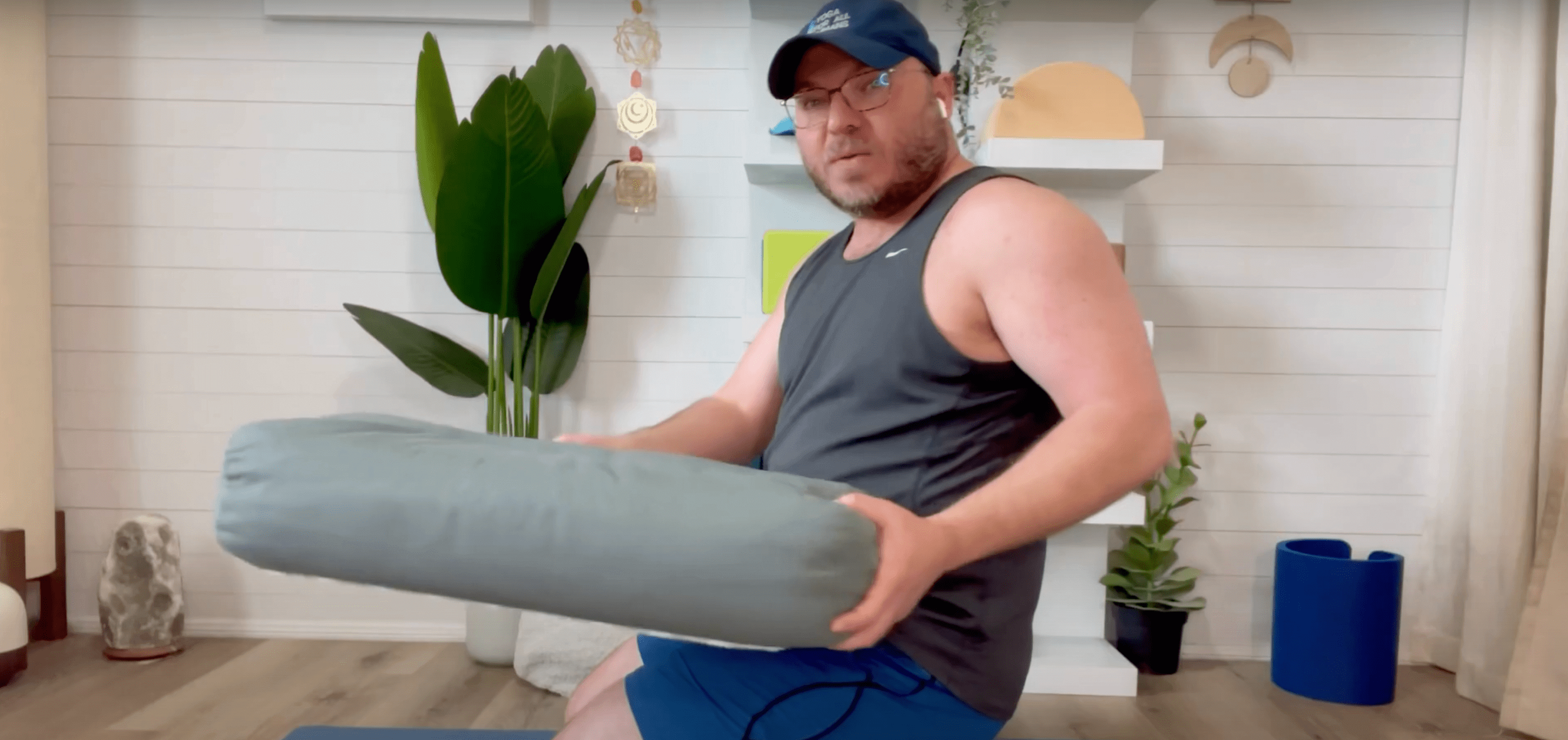 Yoga instructor Derek Haigler using a cushion to help him perform the Thunderbolt yoga pose