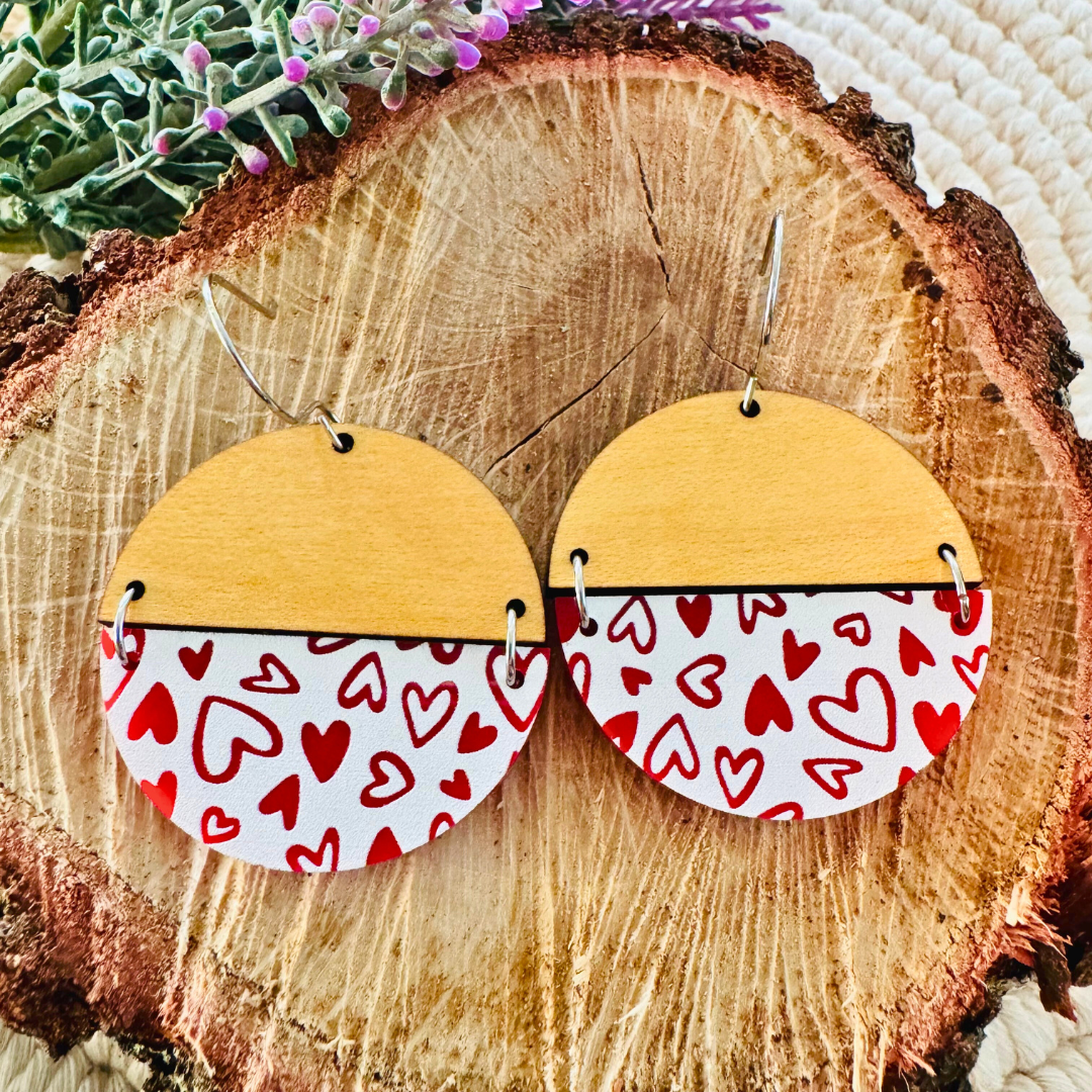Close-up of the Heartfelt Harmony Earrings on a rustic wooden slab, highlighting the red and white heart design.
