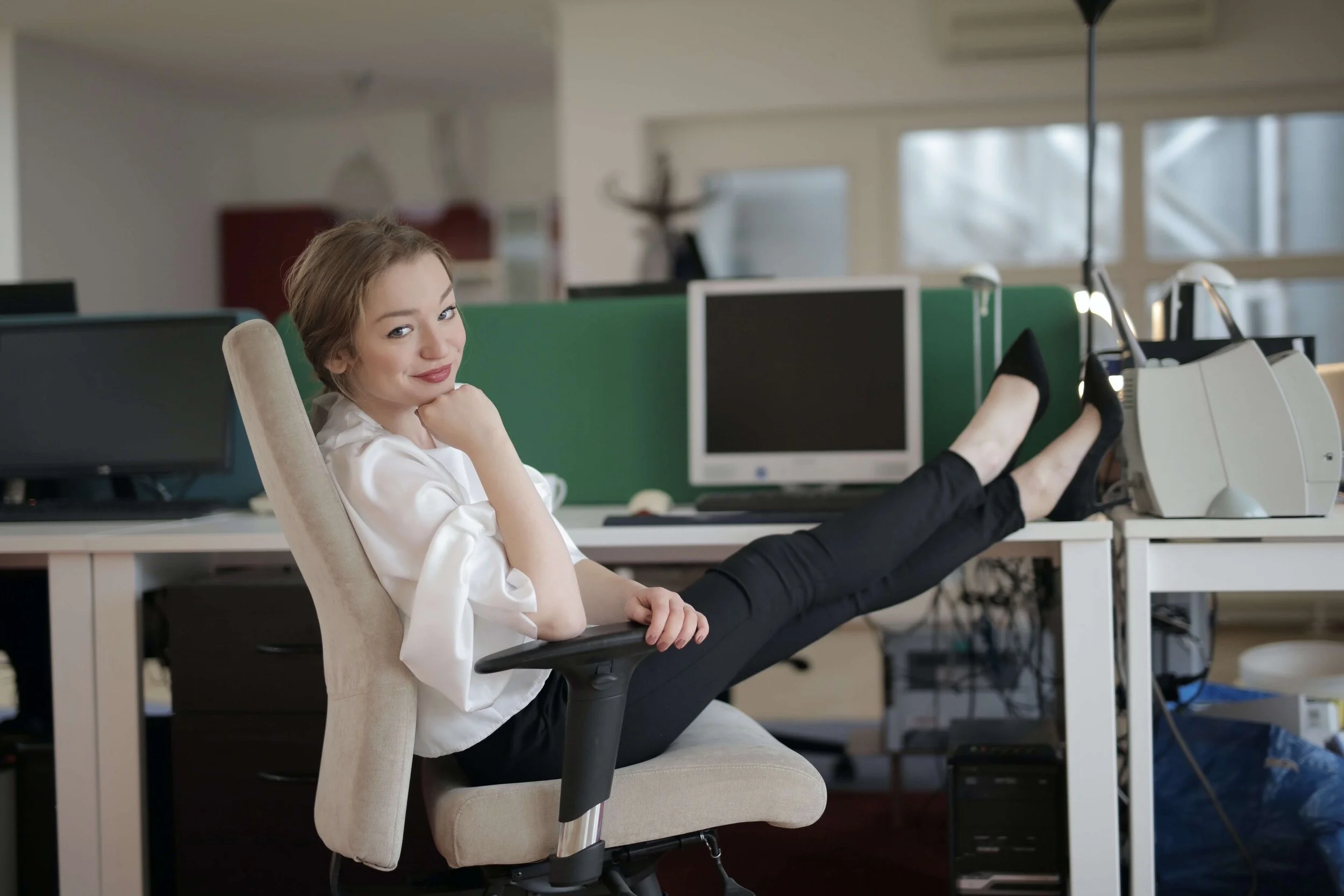 smiling-elegant-female-employee-with-feet-on-table-3791533.jpg