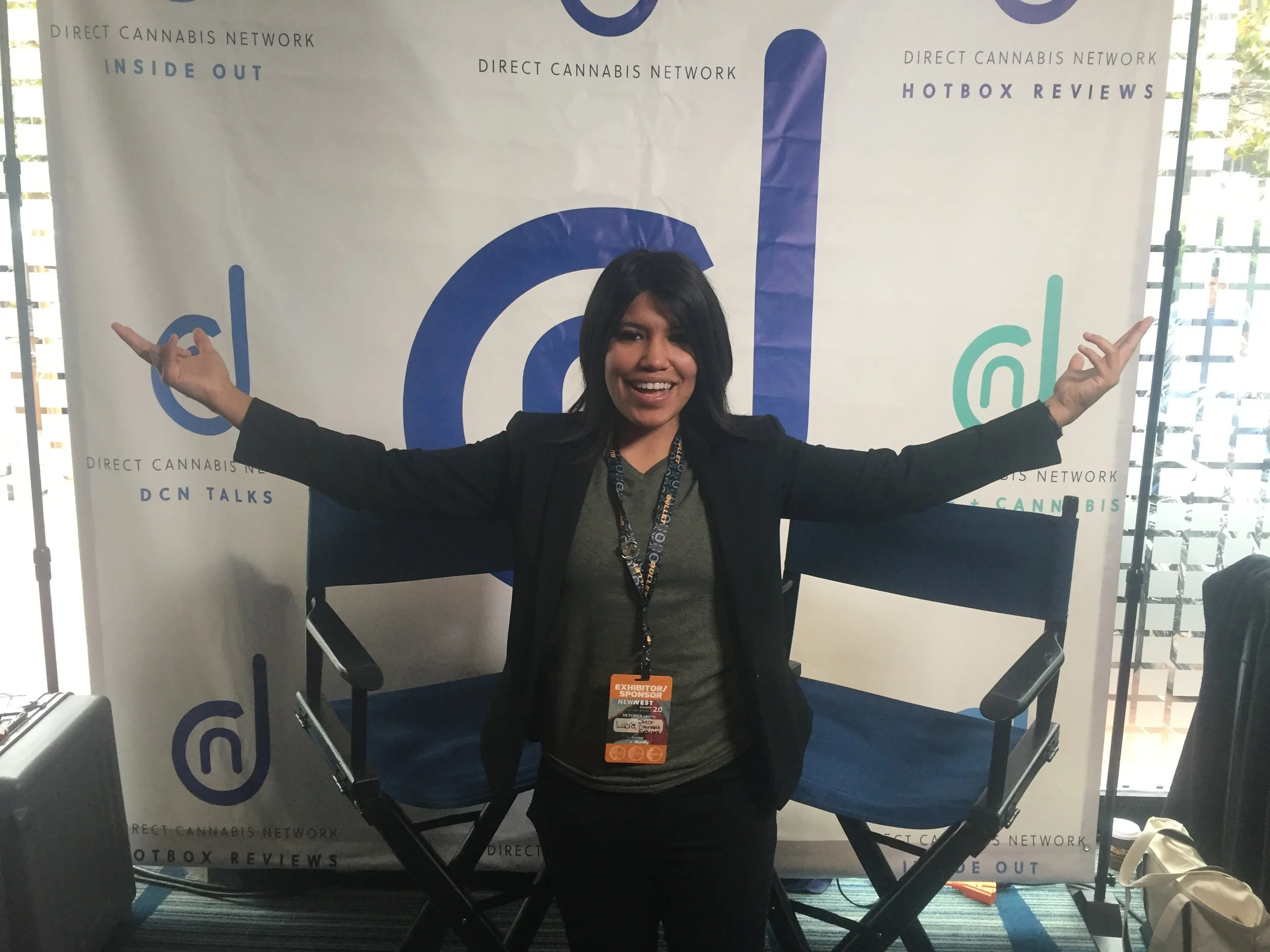 Lucia standing in front of DCN step & repeat backdrop at Oakland 2016 conference.