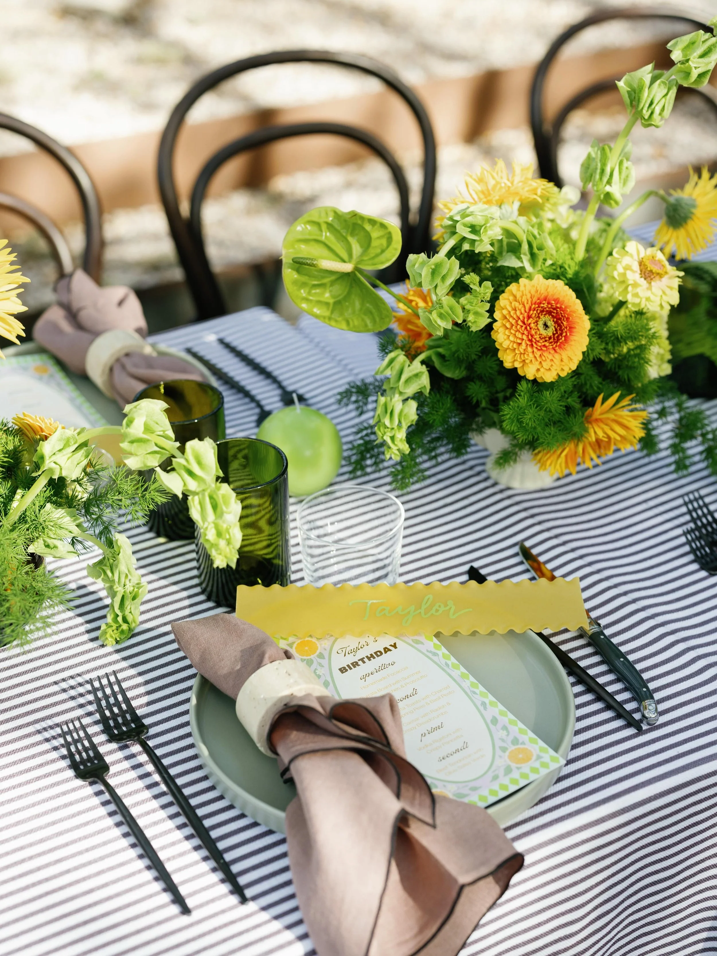 For Taylor&rsquo;s birthday, we designed an intimate dinner party layered with chartreuse florals, brown-and-white striped linens, and classic Thonet chairs. Guests found their seats with names written on pasta ribbon, a playful nod to the evening&rs