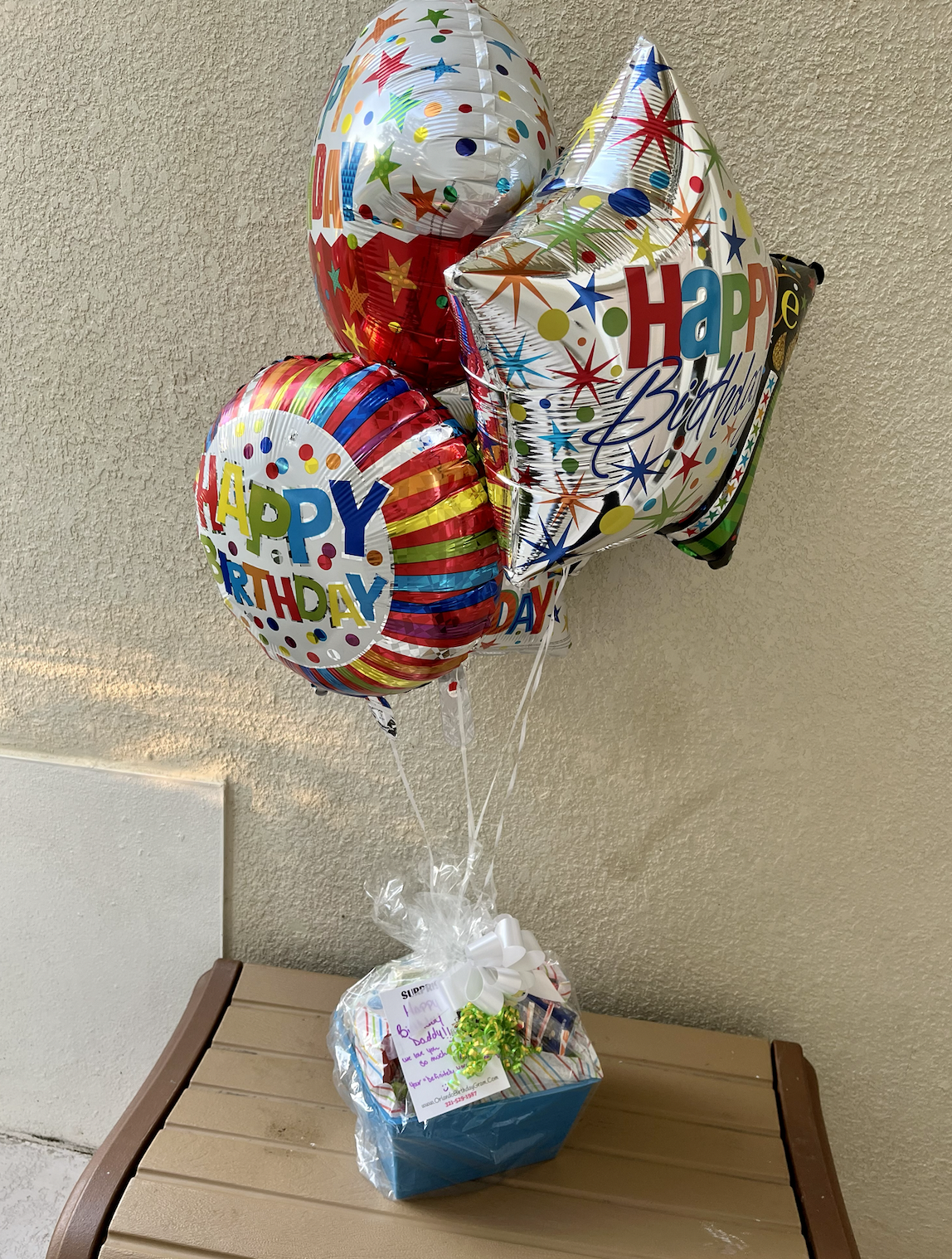 Colorful birthday balloons in a gift basket, with various 