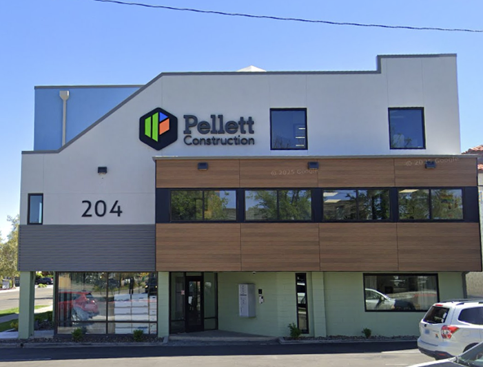 Modern two-story building with Pellett Construction logo, address 204, large windows, and parked cars in front.