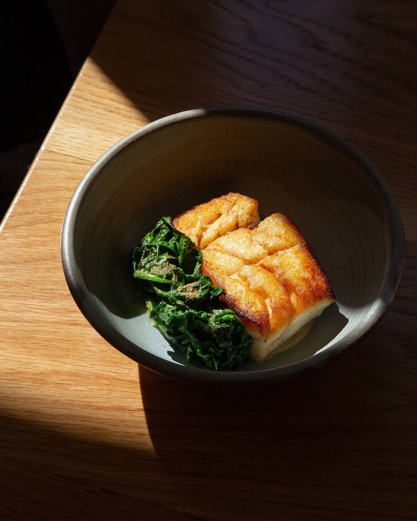 New for spring: Pan-seared Icelandic cod, getting its glow on. Served with creamy sourdough pur&eacute;e &amp; lightly charred spinach dressed up with a wasabi-citrus kick.