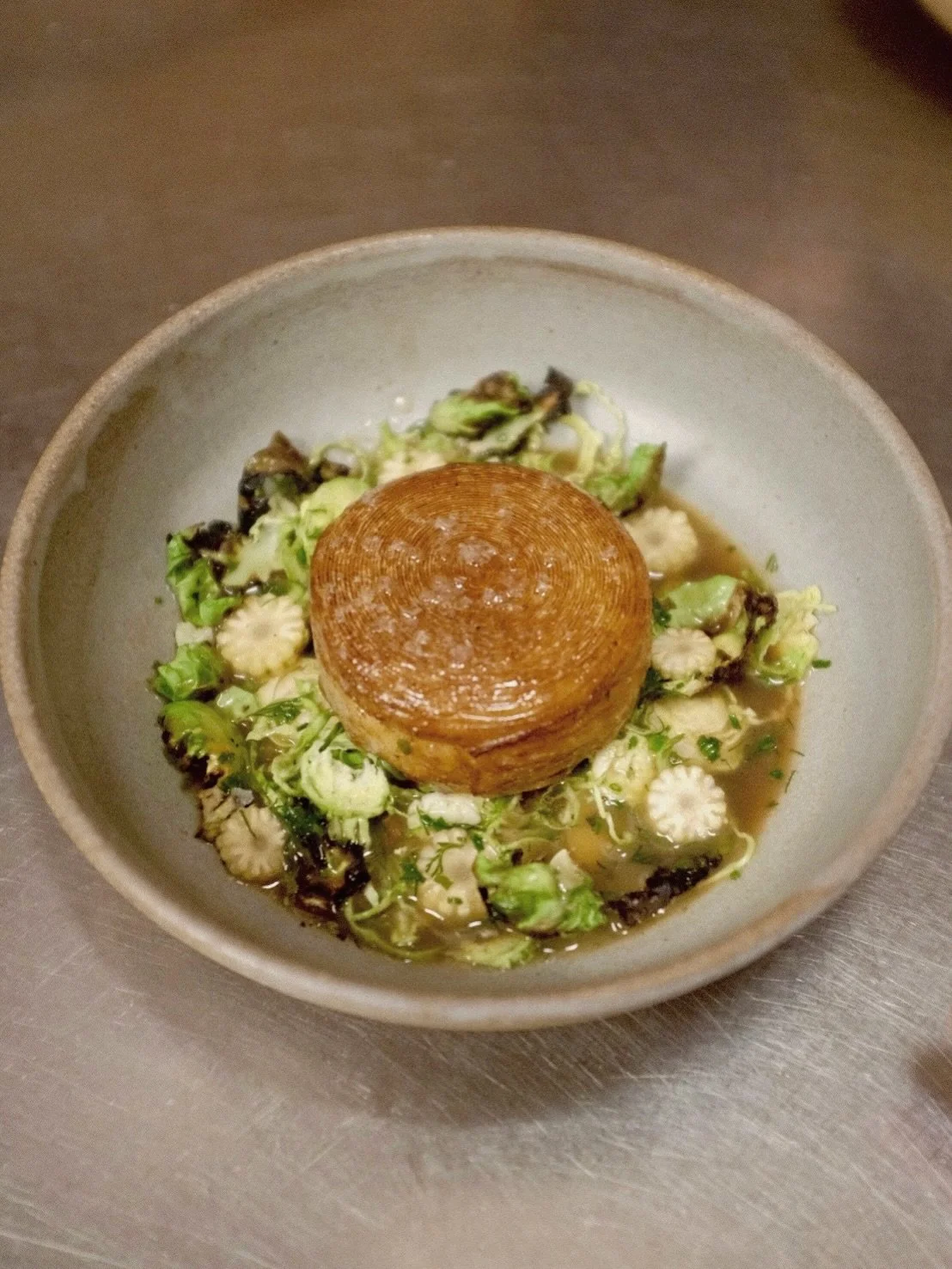 Our celeriac is sheeted, rolled and basted with butter until it is golden brown. Served with a broth of celeriac stock, brussels and horseradish oil. Get it while it lasts