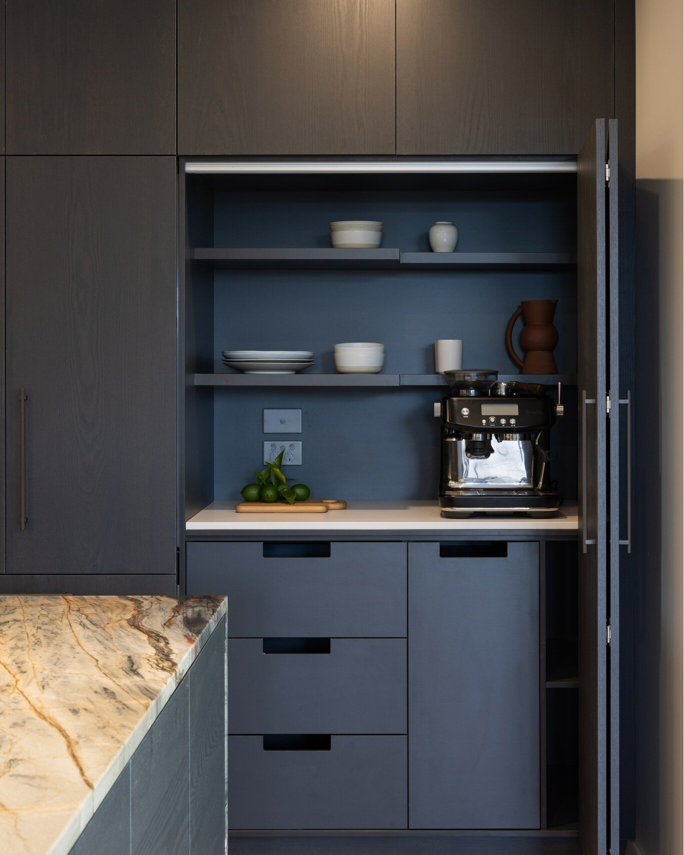 Explore our Mission Bay, Auckland! 
From the intricacies of the cabinetry, revealing cleverly concealed elements like a tucked-away coffee machine, to the striking marble benchtop that elegantly extends alongside the kitchen island, this kitchen woul