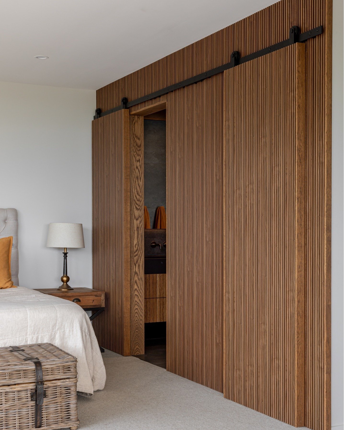 Award-winning design, elevated through detail.
This ensuite combines thoughtful material choices with custom sliding doors that connect seamlessly into the wardrobe space, a refined balance of function and form.

Every element is crafted to complemen