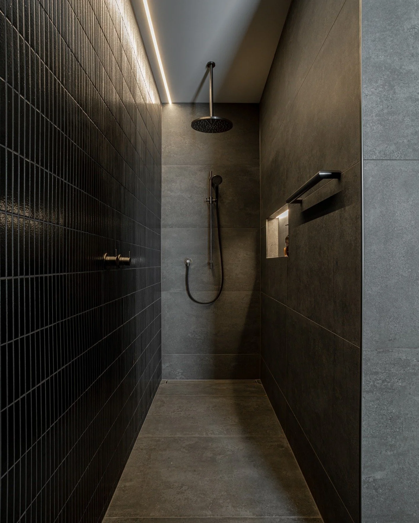 A refined mix of texture and tone. This ensuite pairs rich charcoal tiles with timber accents, creating contrast and warmth in equal measure. Attention to proportion, lighting and detail brings calm to every surface. Another example of bringing our c