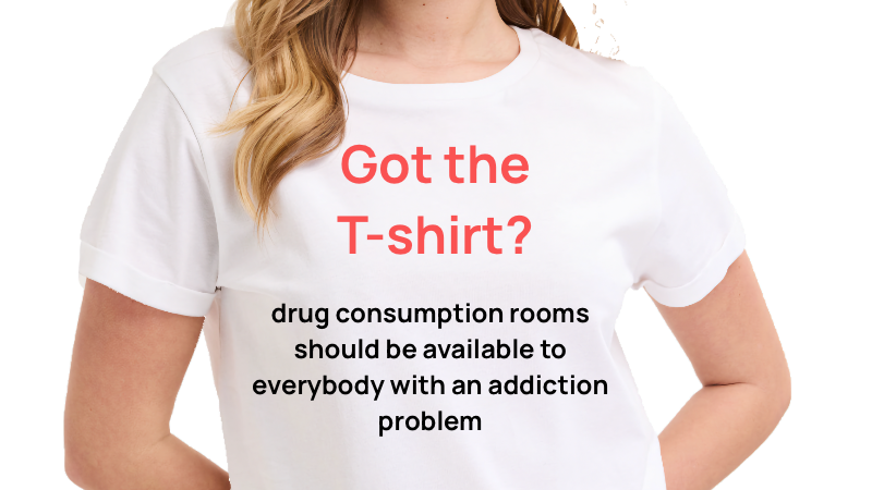 A woman wearing a white T-shirt with red and black text promoting drug consumption rooms for addiction support.