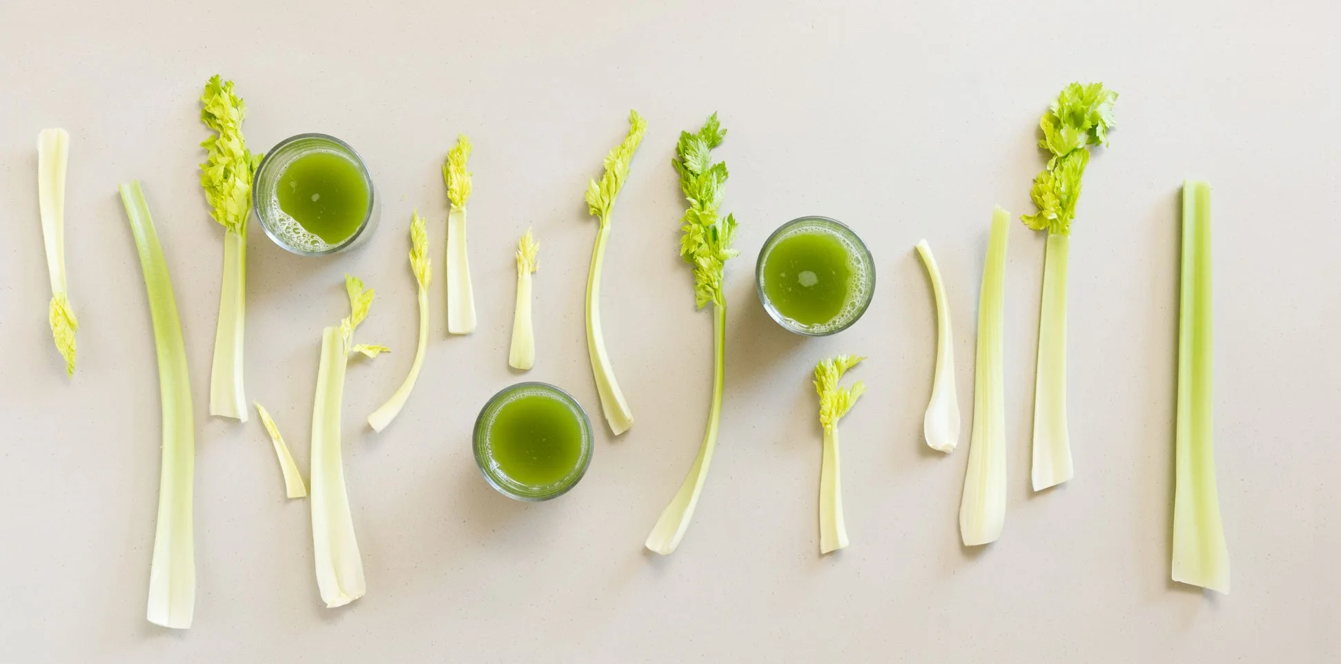 Gläser mit Selleriesaft und Selleriestangen grafisch angeordnet