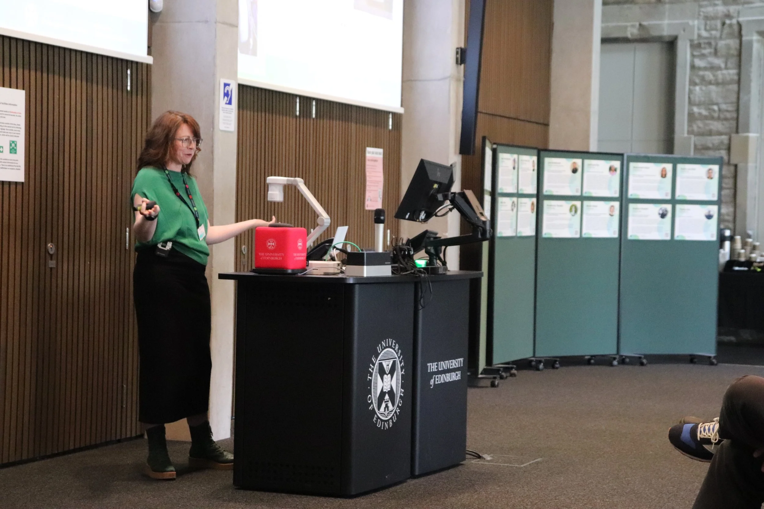 Bríd-Áine Parnell is stood behind the teaching desk, mid-presentation