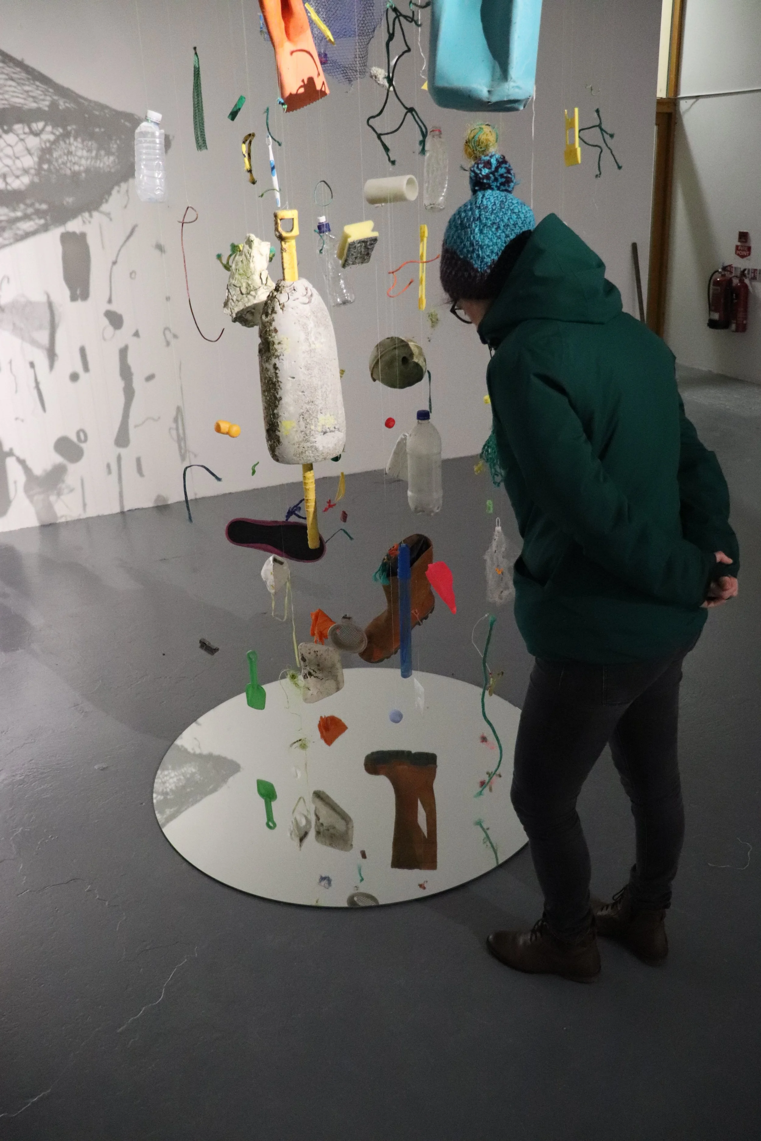 Some sea  floating, but moored, 2021.
Found sea trash, found plastics, fishing net, fishing line, a mirror, and a stone
