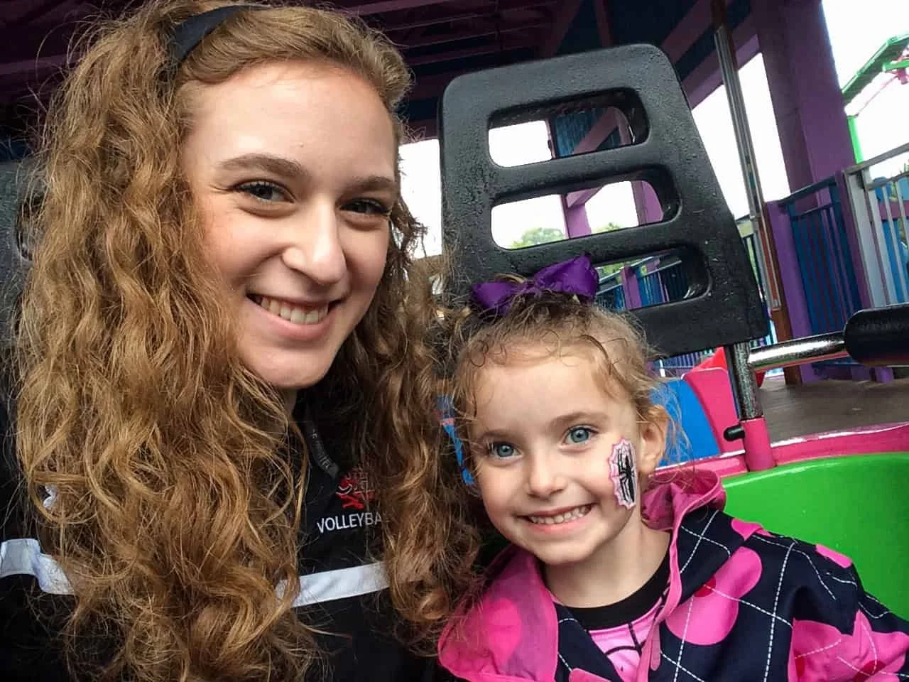 Two family members smile on a ride at Busch Gardens, one with spider face paint, during the Halloween Spooktacular.