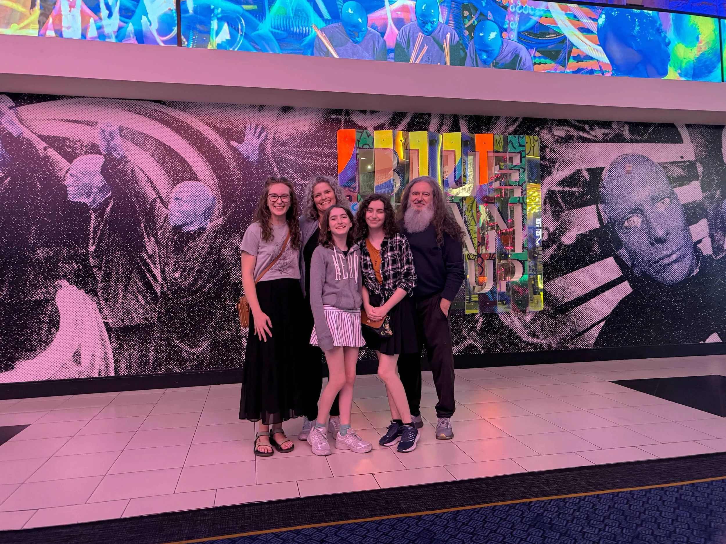 A family of 5 standing outside the entrance to the Blue Man Group, Luxor, Las Vegas Nevada.