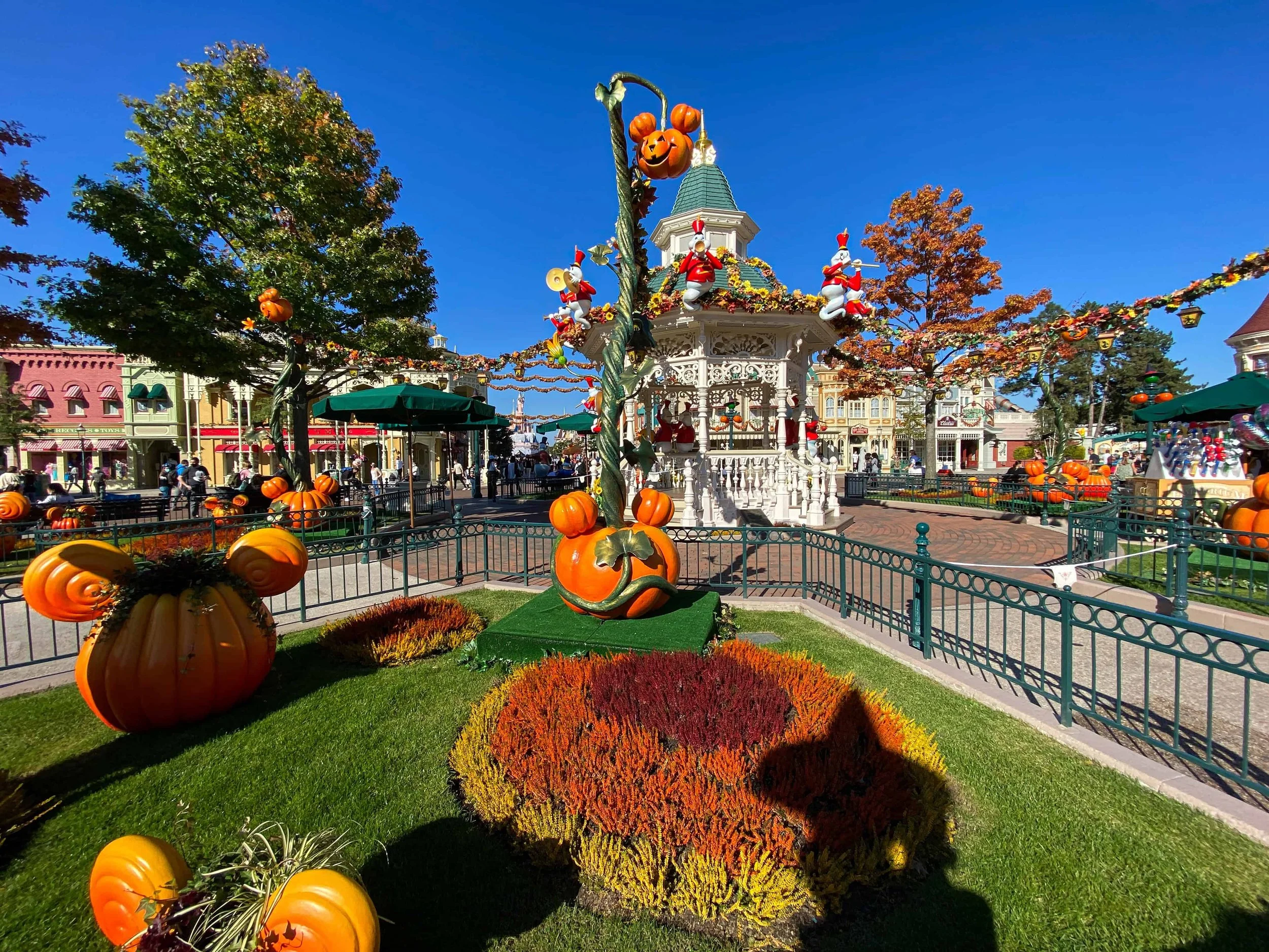 Mickey-shaped pumpkins and autumn decor near the Main Street gazebo at Disneyland Paris during the Halloween season.
