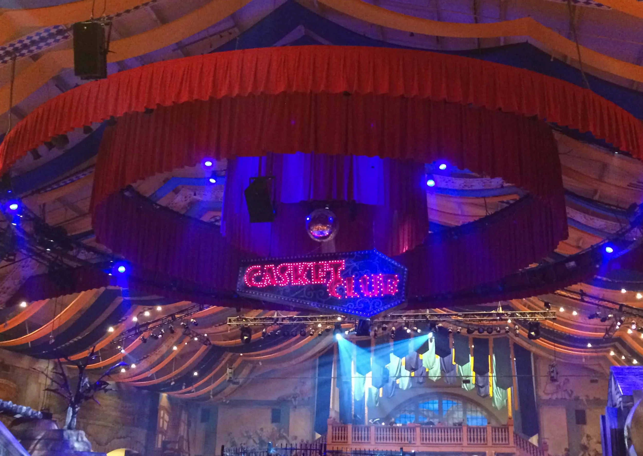 The Casket Club stage inside Das Festhaus, lit in red and blue for Howl-O-Scream at Busch Gardens Williamsburg.