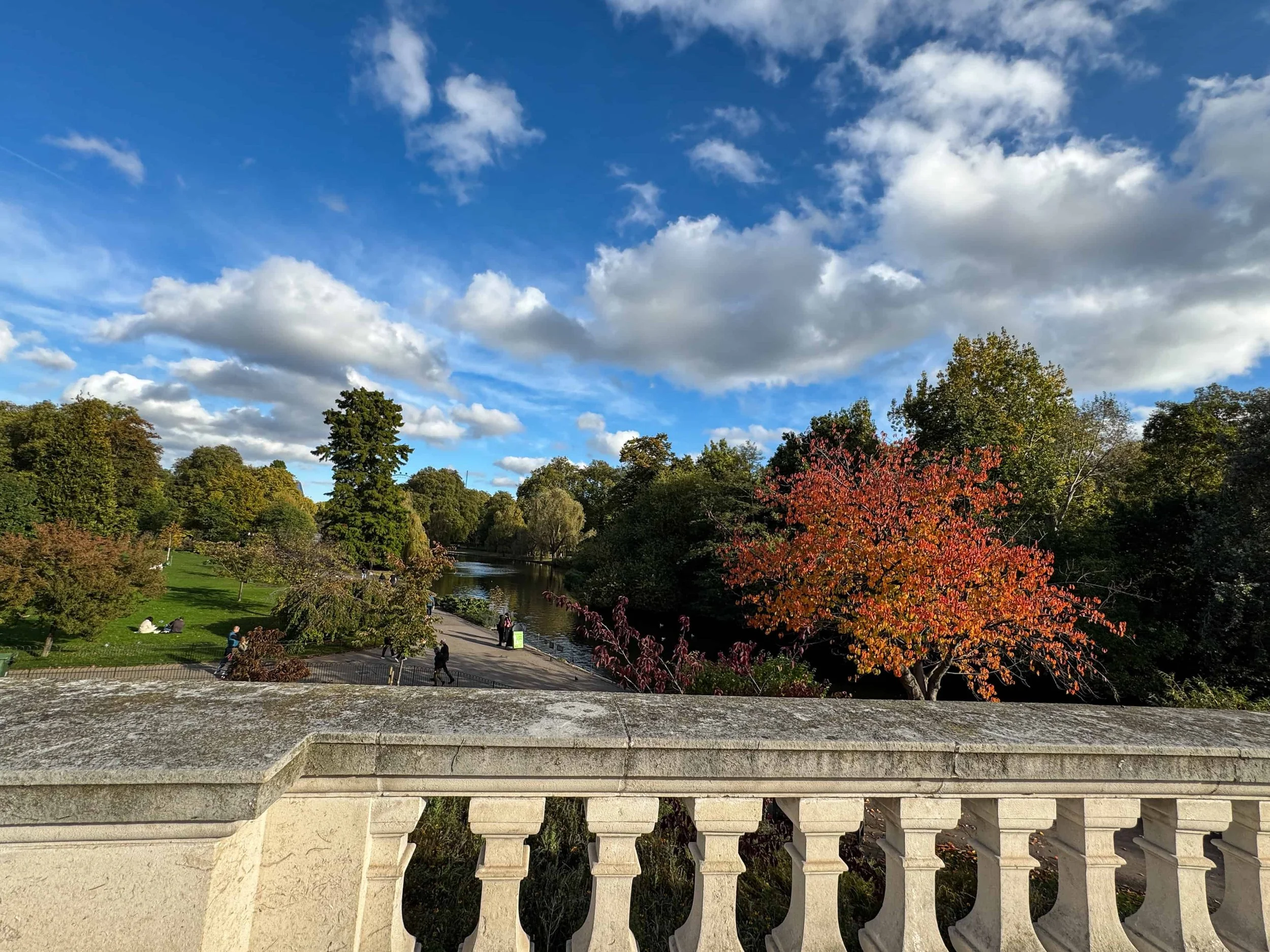 Vibrant autumn fall colors and lake in St James’s Park London – beautiful free park with views toward Buckingham Palace.