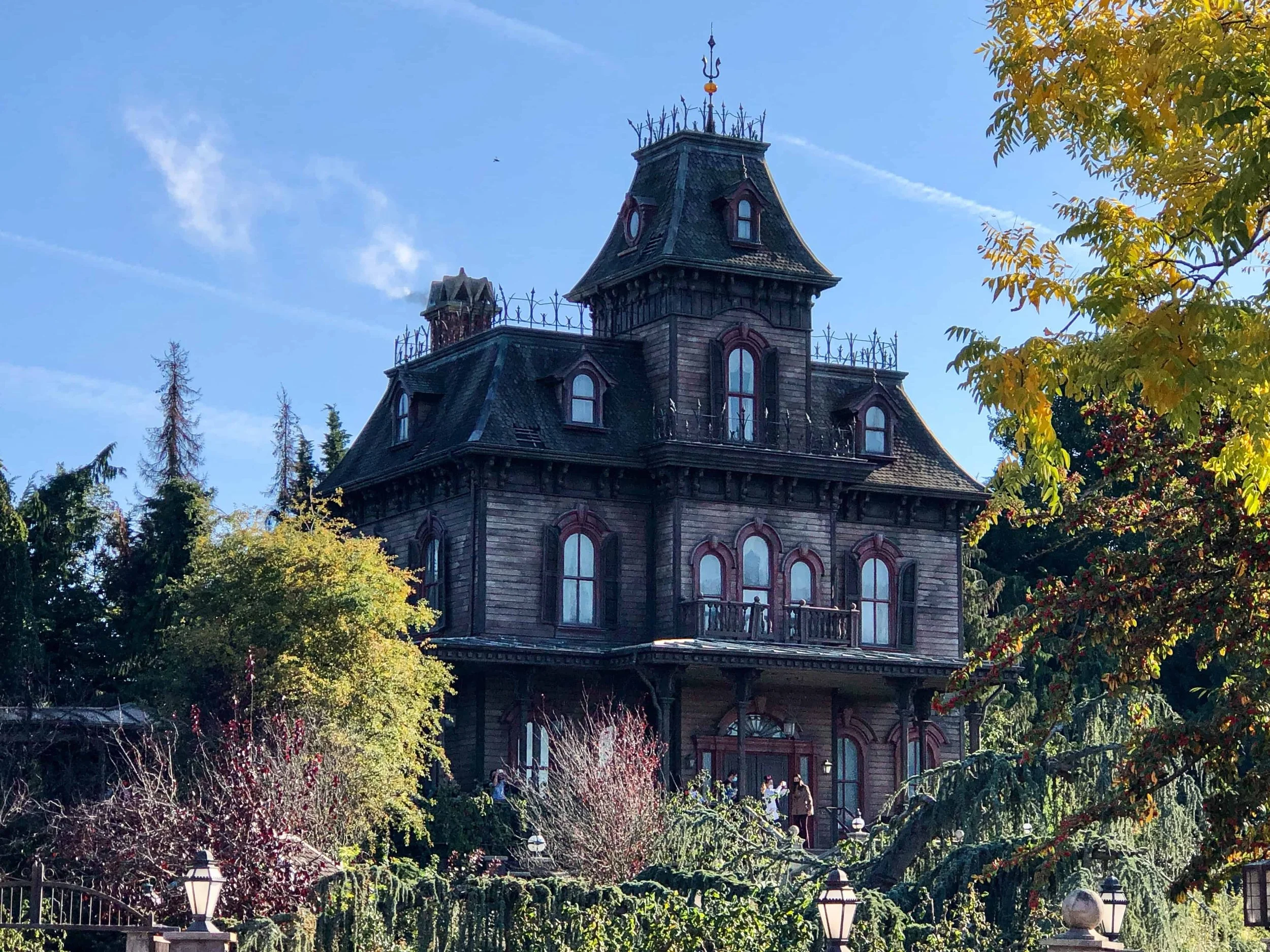 Phantom Manor, the haunted mansion attraction at Disneyland Paris, rising above the autumn trees.