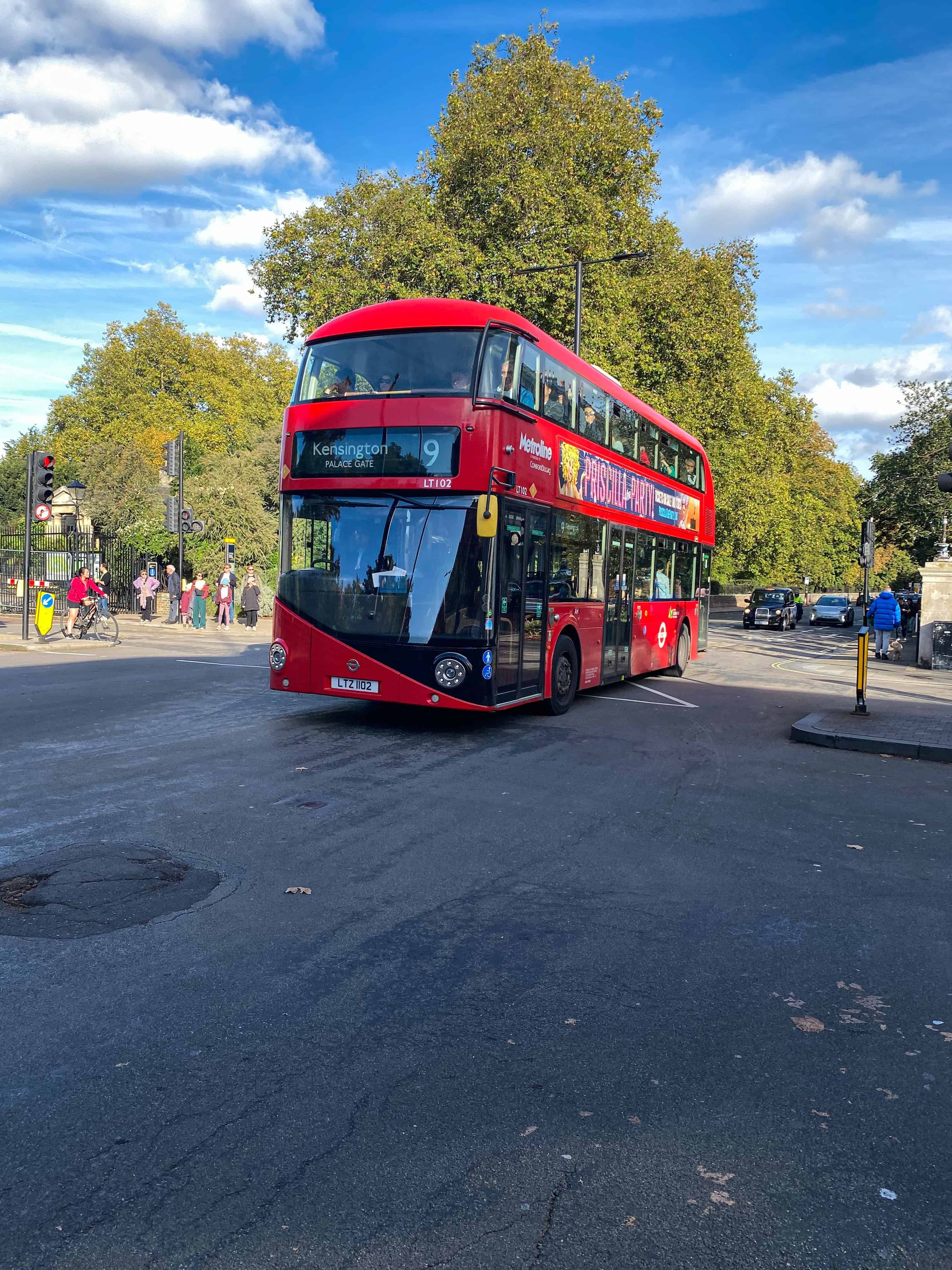 Iconic red double-decker bus on a London street – affordable way to see the city during family travel.
