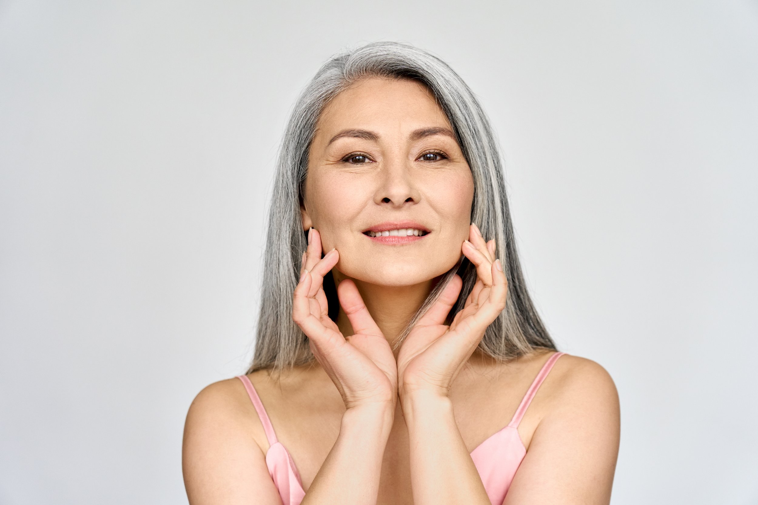 Older woman with beautiful skin touching her face