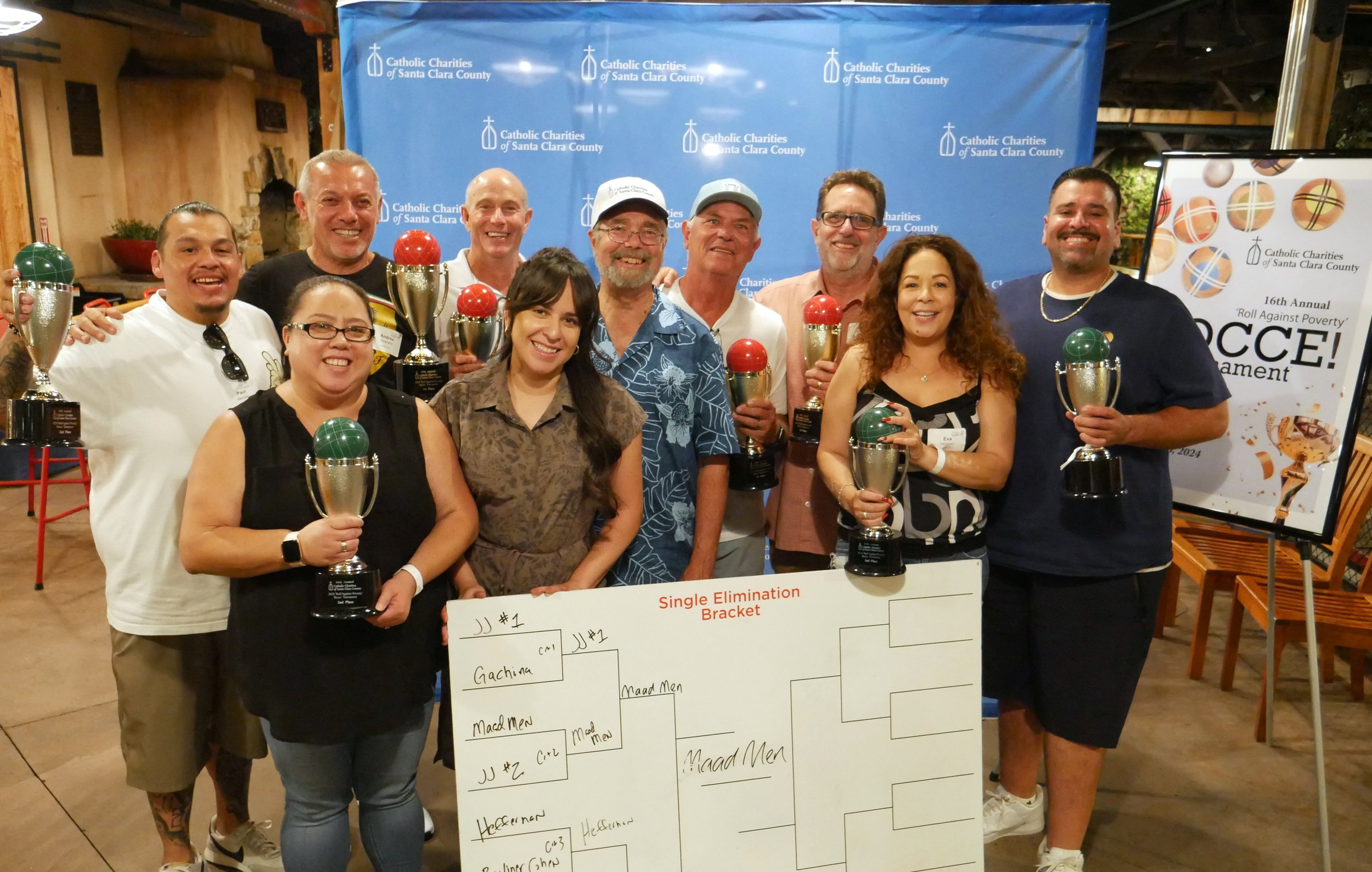 A group of players smiling and holding their trophies after the game.
