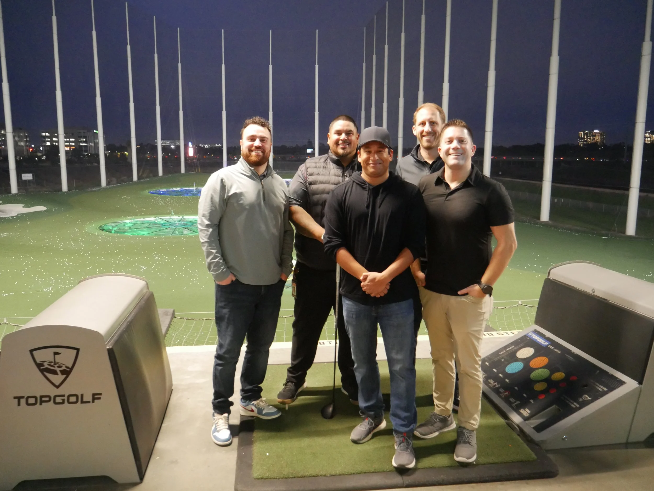 A group of players posing for a picture with the field on the background.