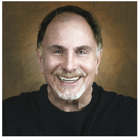 Close-up of a smiling middle-aged man with a beard and mustache, wearing a black shirt, against a brown background.