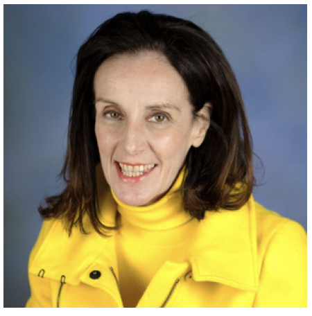 A woman with dark hair wearing a bright yellow jacket and turtleneck smiling against a blue background.