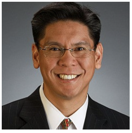Professional headshot of a man in a suit smiling