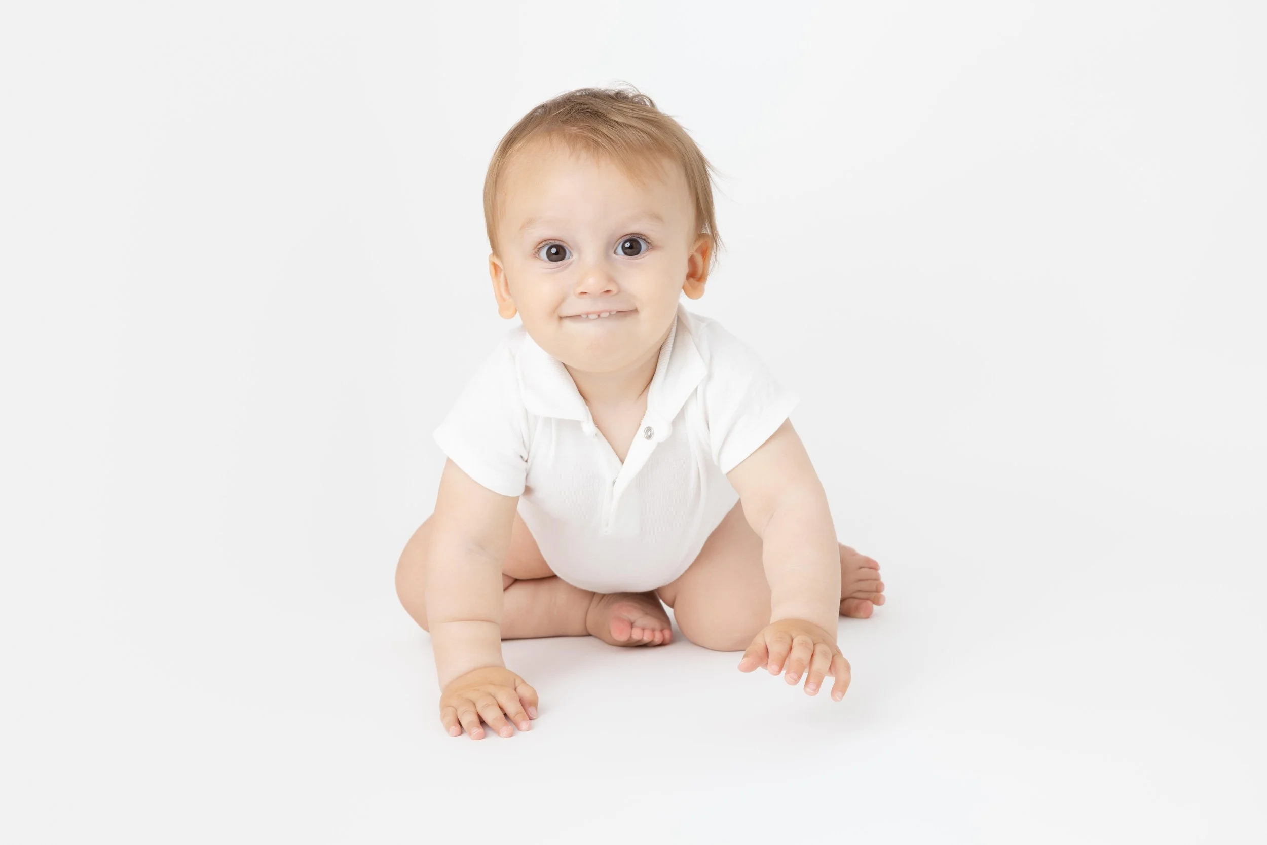 bébé en habit blanc qui rampe 