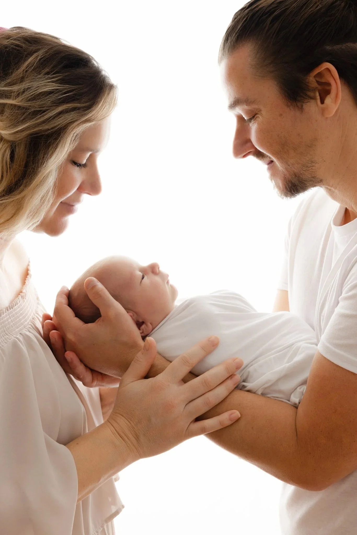 papa et maman avec nourrisson pour séance photo en contre jour