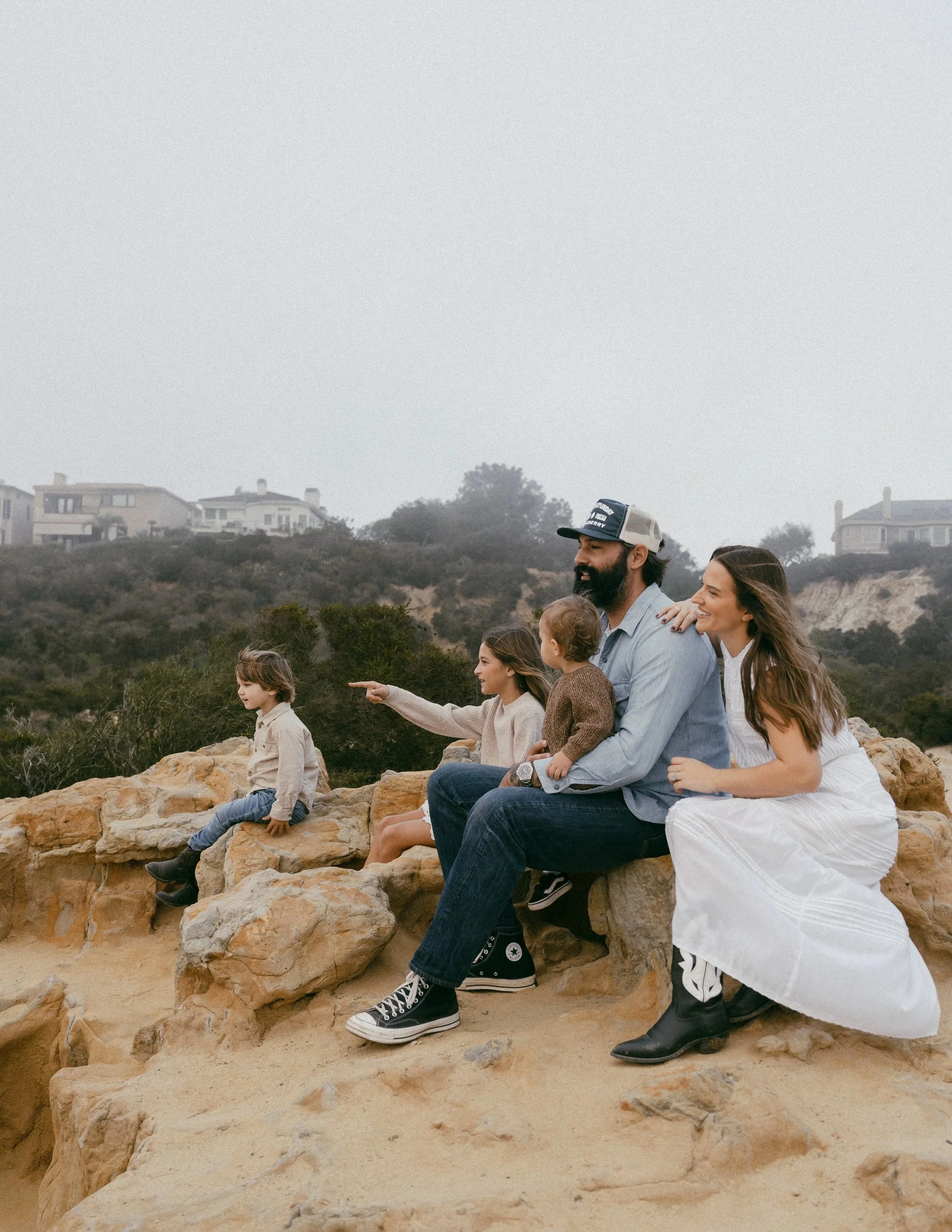 family sitting on rocks in orange county