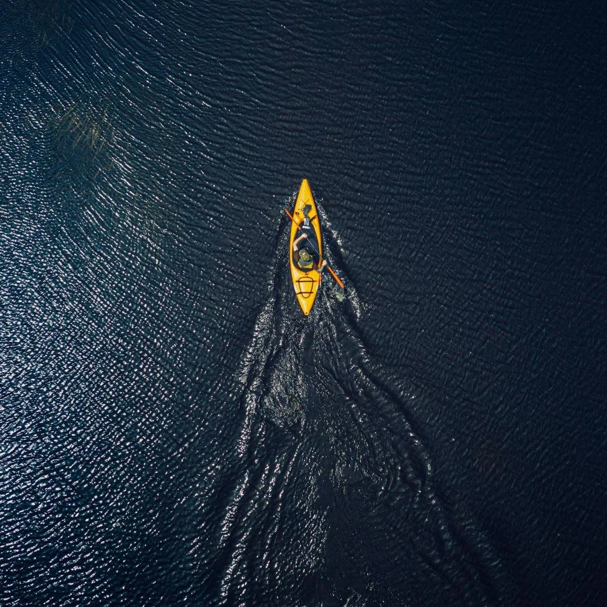 a kayaker on a lake photographed from high above