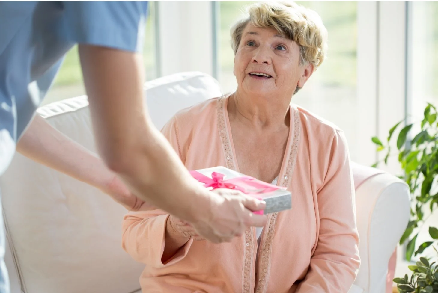 Elderly parent receiving meaningful birthday gift from adult daughter