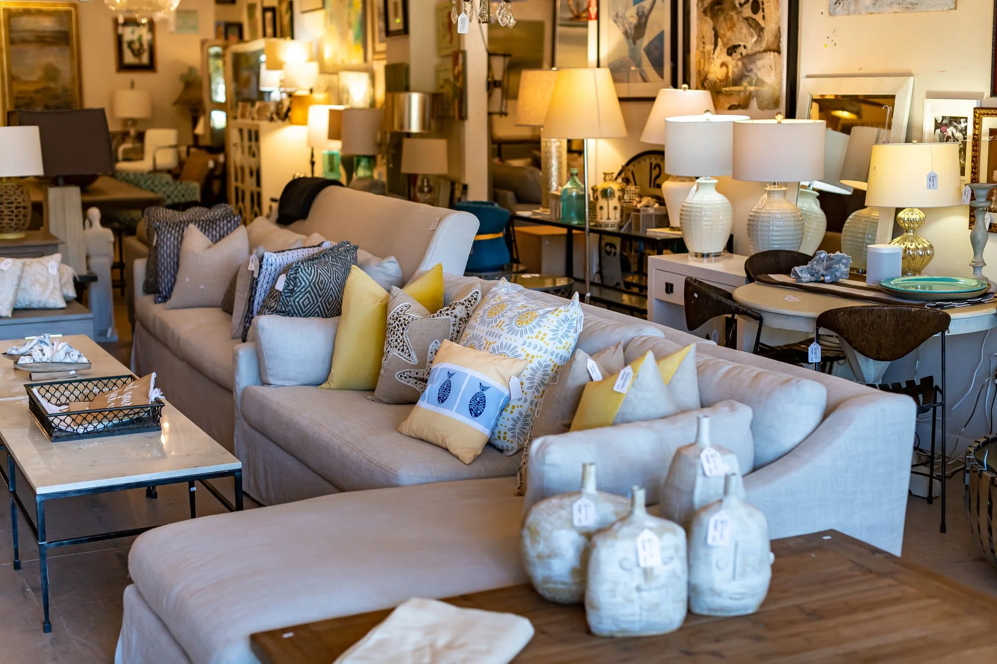 A furniture store display with sofas, pillows, lamps, and decorative items.