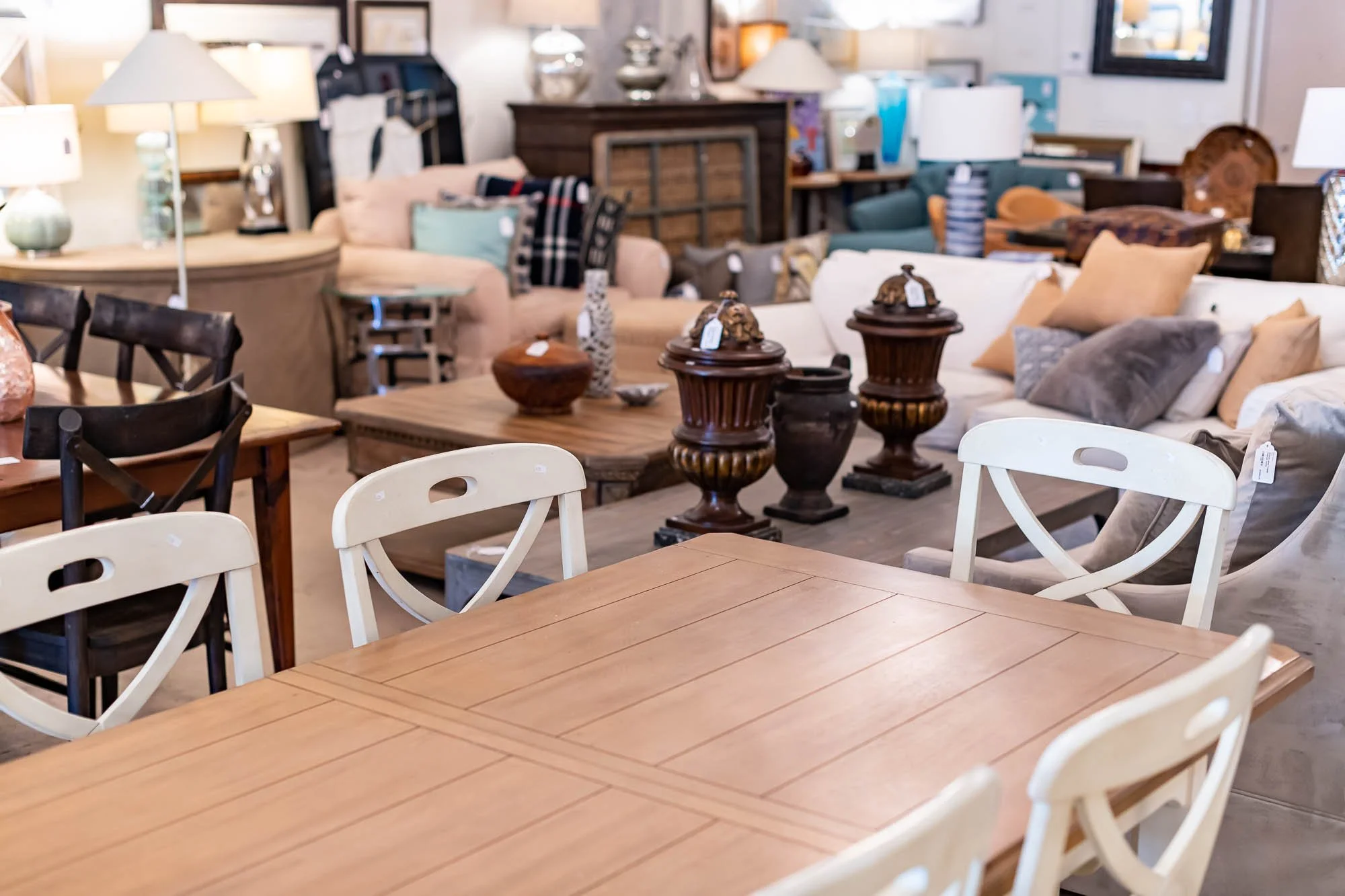 Furniture store display with sofas, tables, and decorative items like vases and lamps.