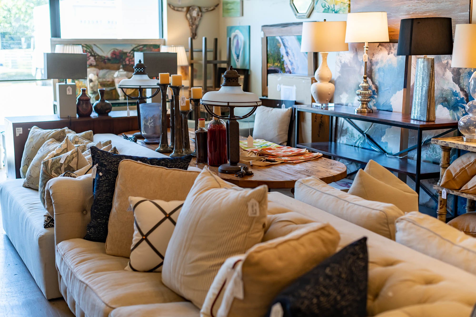 Furniture store display with sofas, throw pillows, lamps, and decorative items.