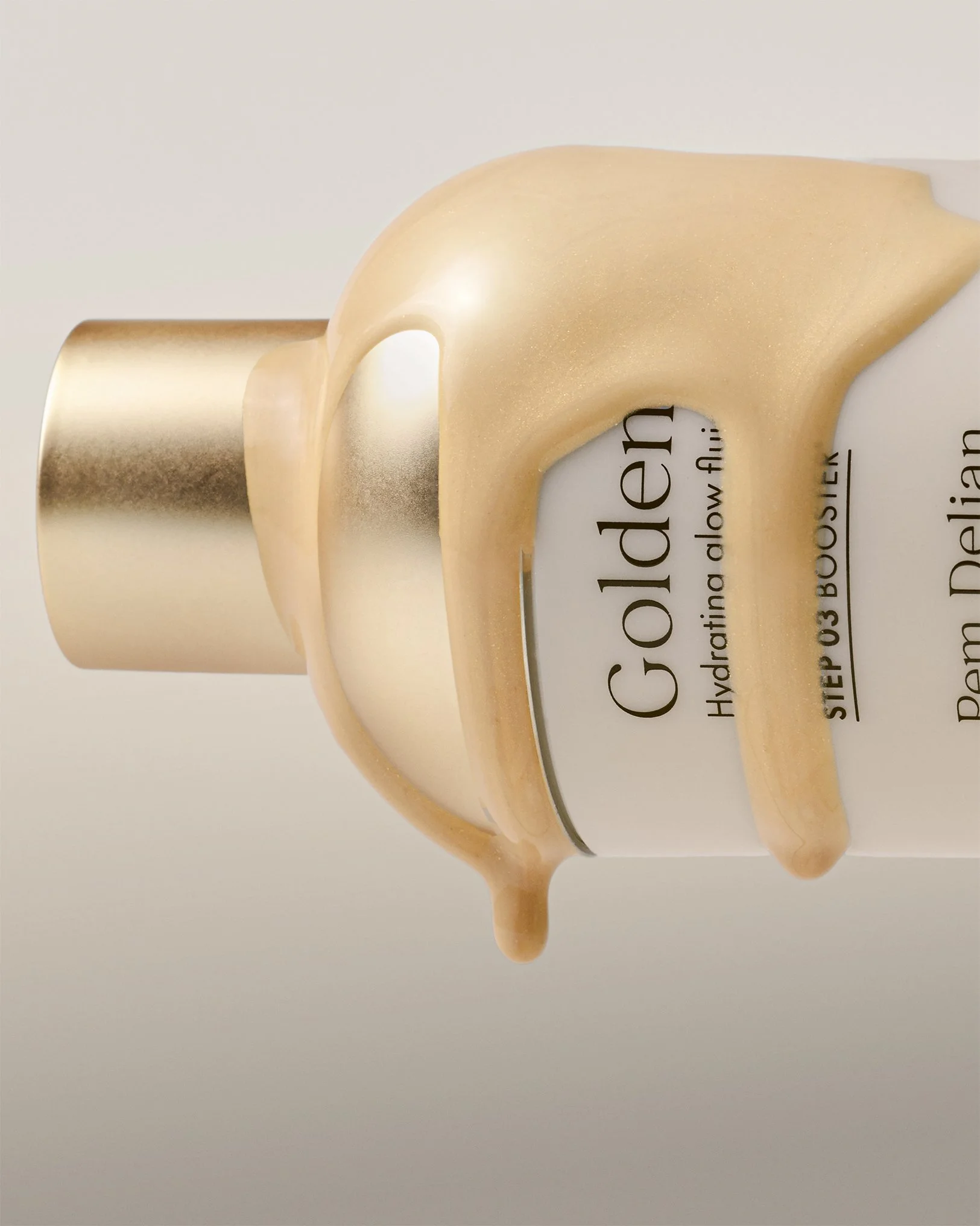 Close-up of golden hyaluronic glow fluid dripping from pump of Pem Delian Golden Up hydrating booster bottle