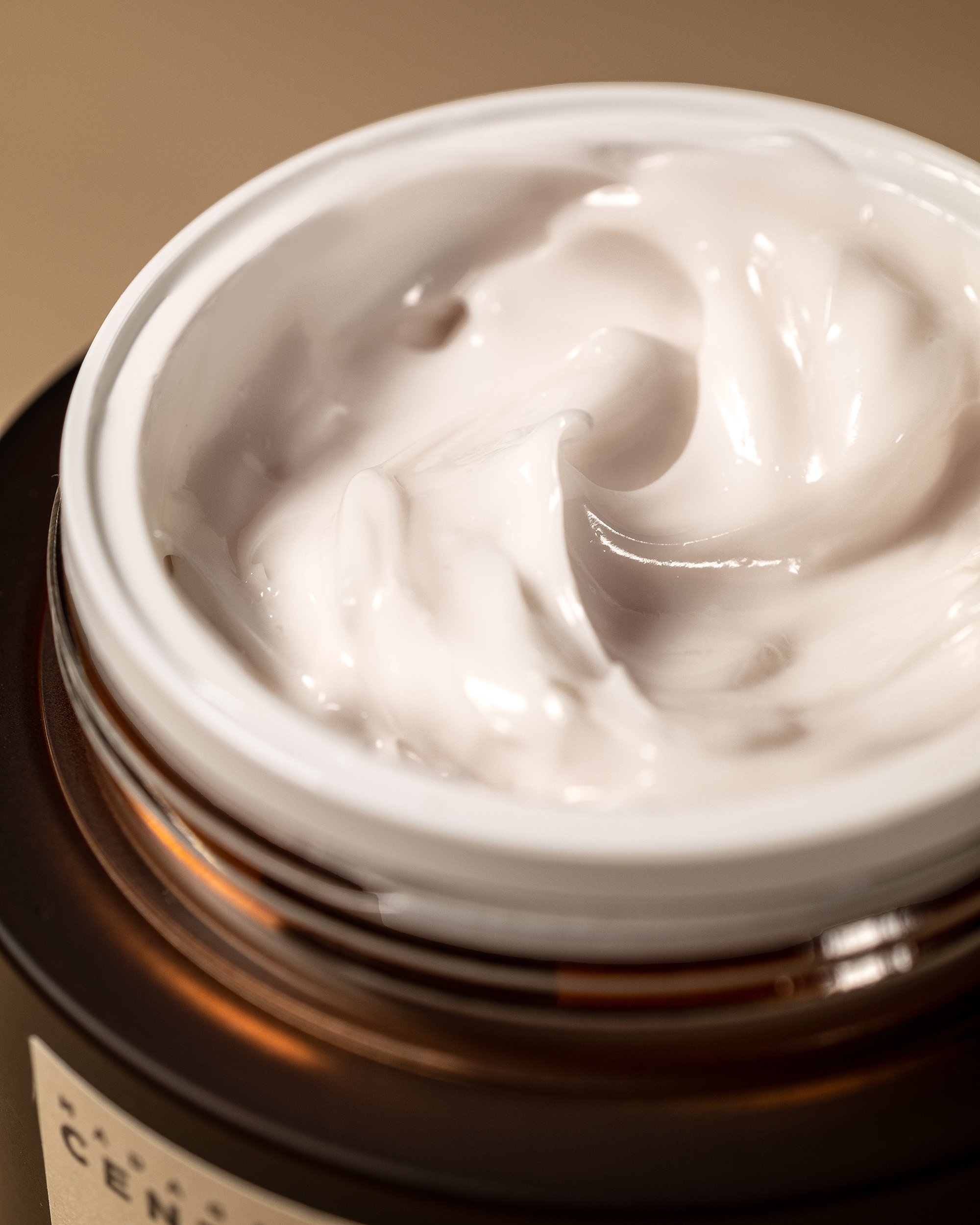 Open skincare jar filled with smooth white cream photographed in soft directional light showing realistic product consistency.