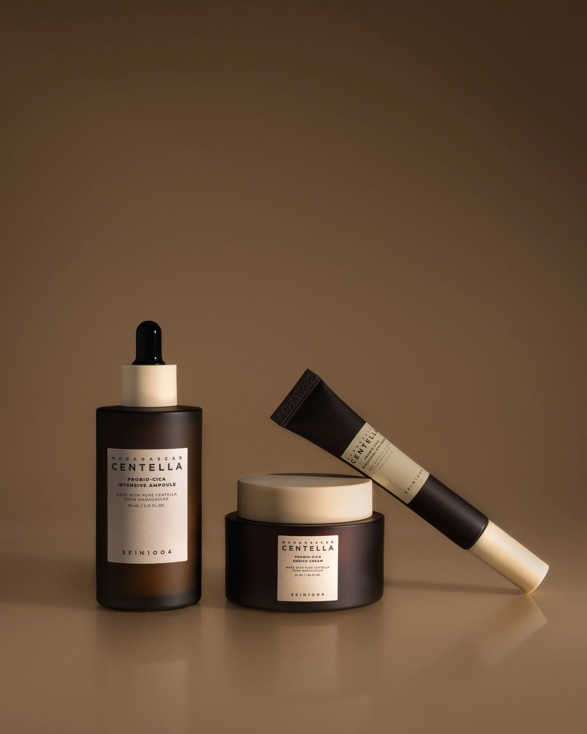 SKIN1004 Madagascar Centella Probio-Cica skincare set including ampoule, cream and tube, photographed with soft studio lighting on a beige background for premium beauty branding and e-commerce use.