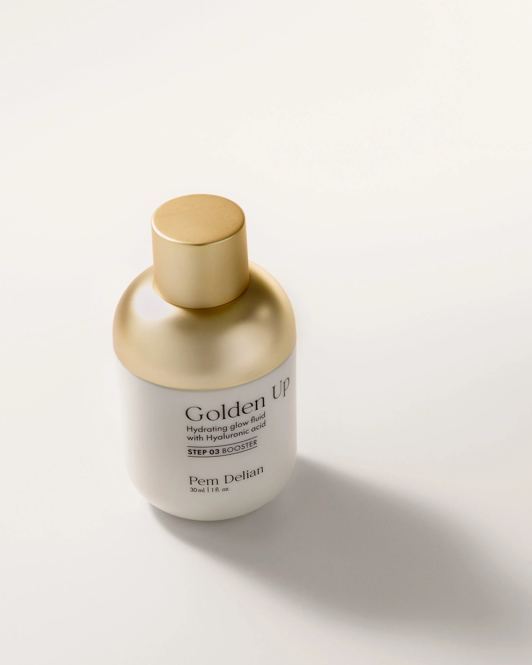 Pem Delian Golden Up hydrating glow booster with Hyaluronic acid standing upright with matte gold cap on white background