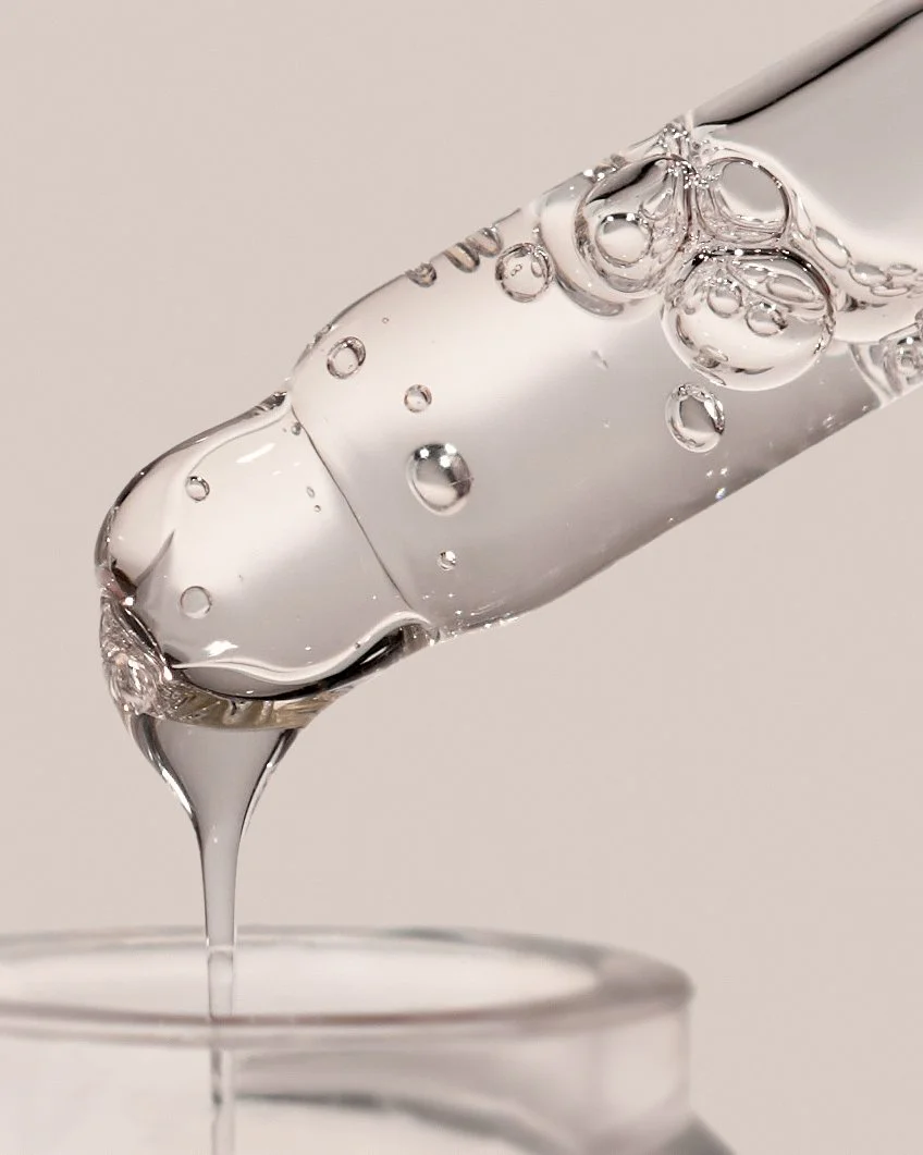 Extreme close-up of Pem Delian Age Expert Botox-like peptide serum dripping from dropper tip