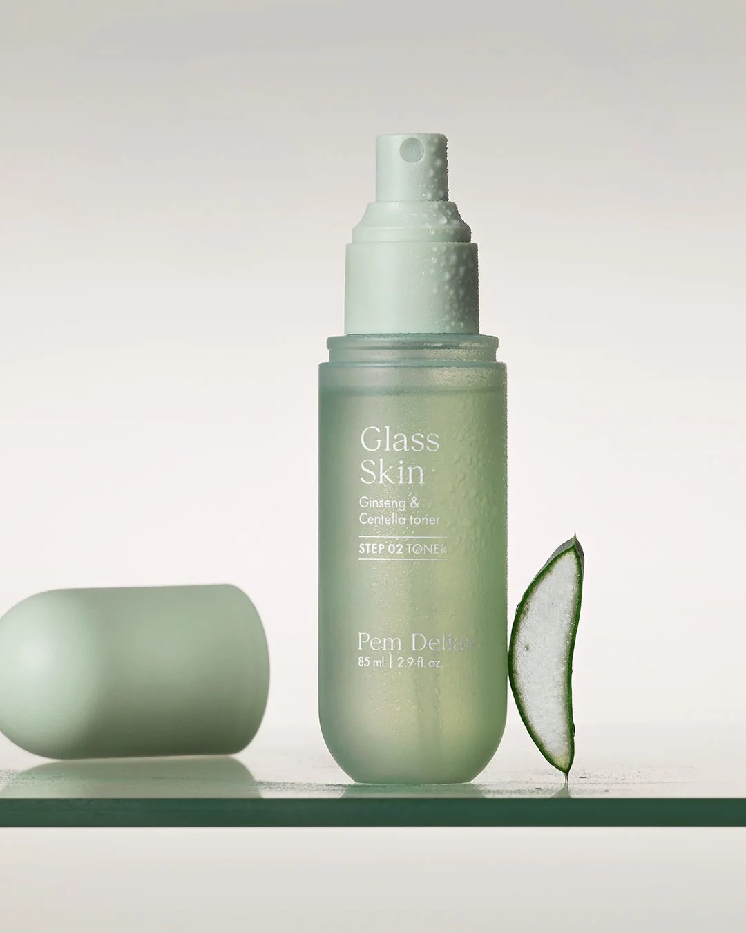 Close-up of Pem Delian Glass Skin Ginseng & Centella toner dripping from a dropper.