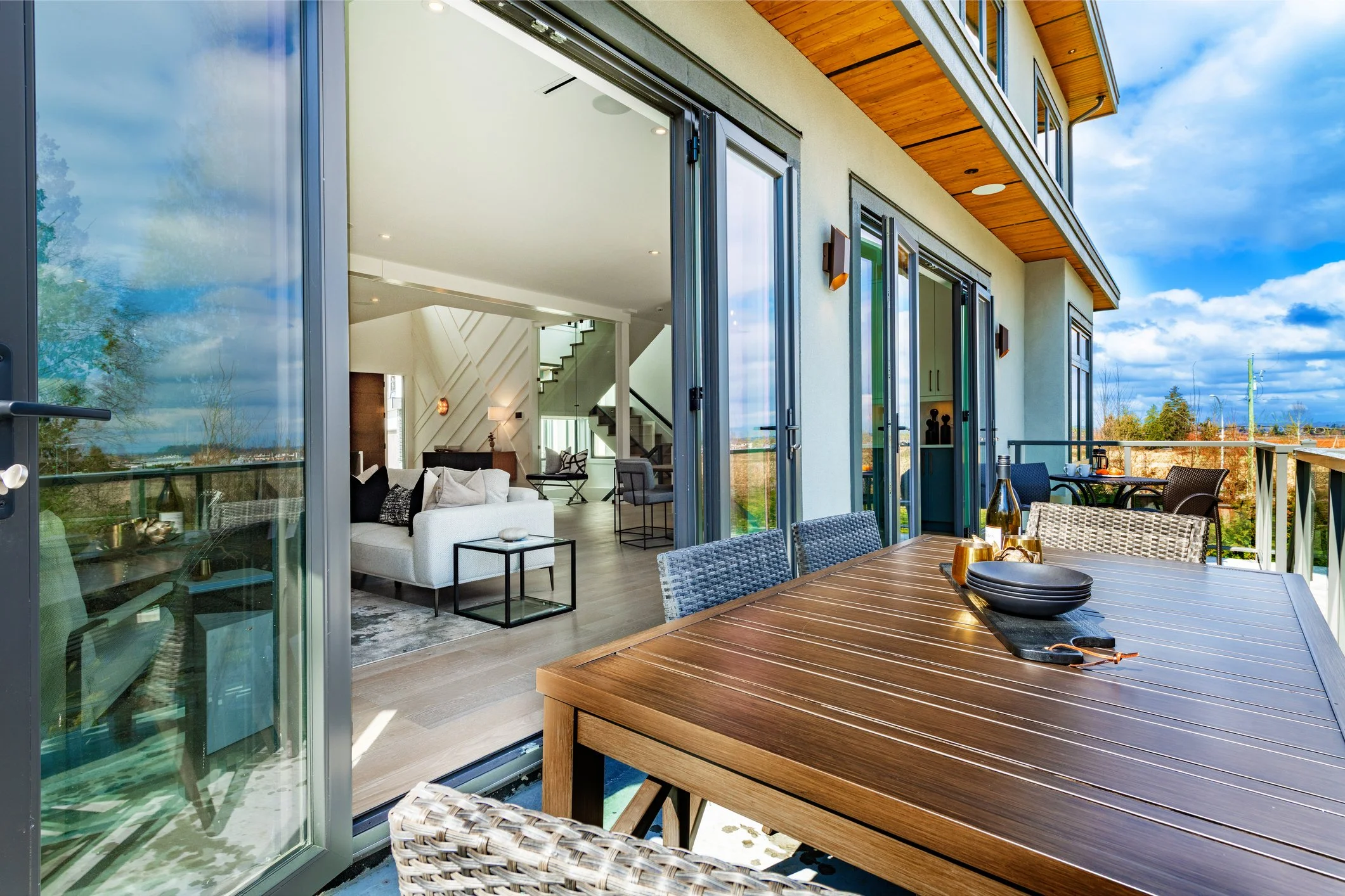 Indoor-outdoor living space featuring modern patio dining, folding glass doors, and warm contemporary home design inspiration.