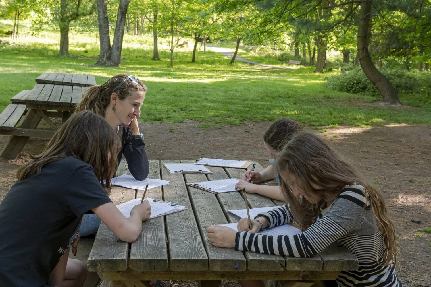 A mentor with young participants outdoors