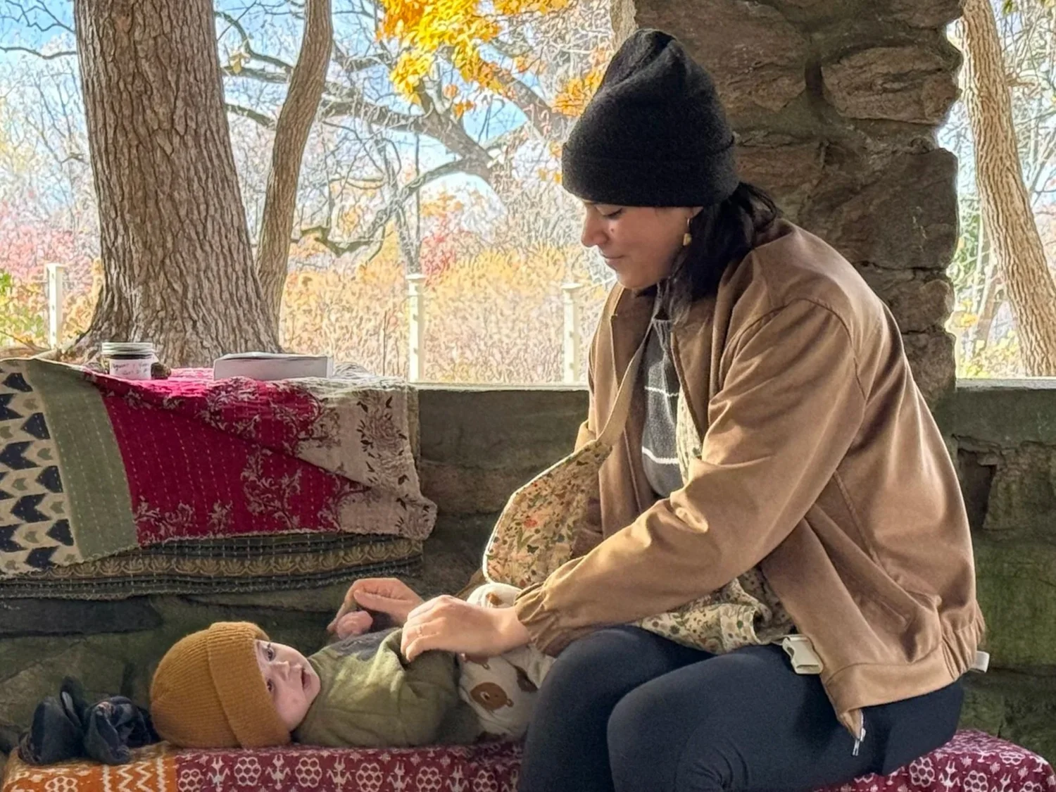 A caregiver holding a baby outdoors