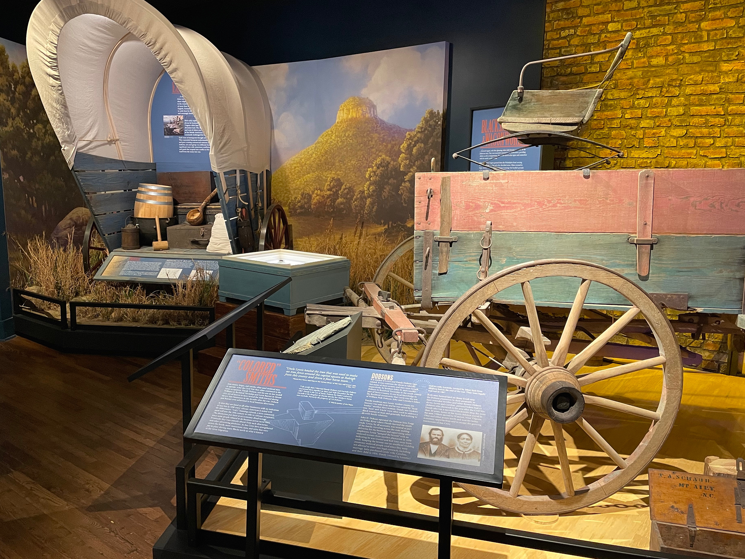 Museum exhibit with wagon, mural and artifacts