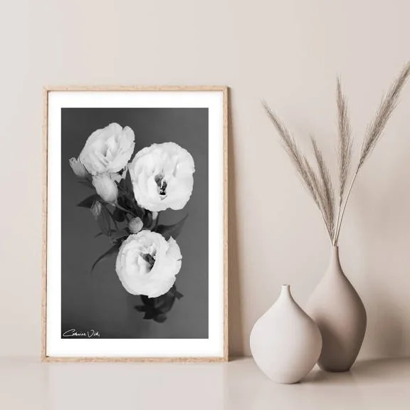 framed black and white wall art print of white flowers sitting next to vases